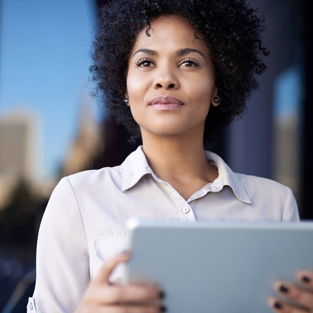 Woman using iPad looking into the distance