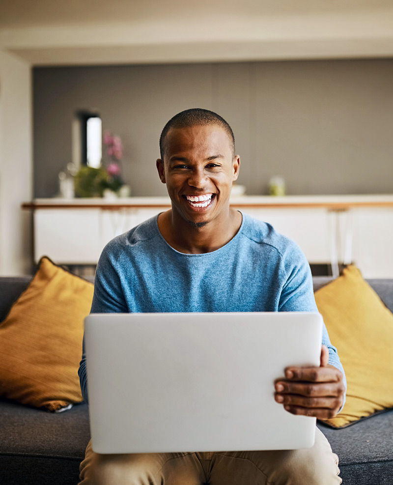 Man smiling holding a computer