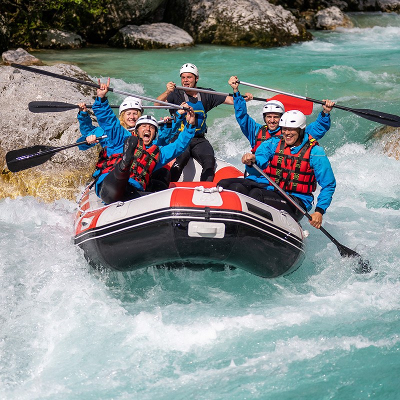 White water rafting team holding paddles inside a raft